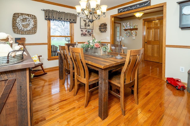 dining area with baseboards, a notable chandelier, crown molding, and light wood-type flooring