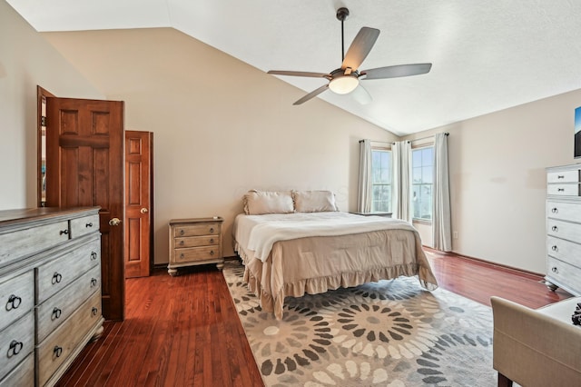 bedroom featuring dark wood finished floors, vaulted ceiling, and a ceiling fan