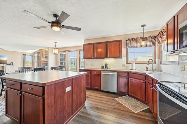 kitchen with a sink, dark wood finished floors, backsplash, a ceiling fan, and dishwasher