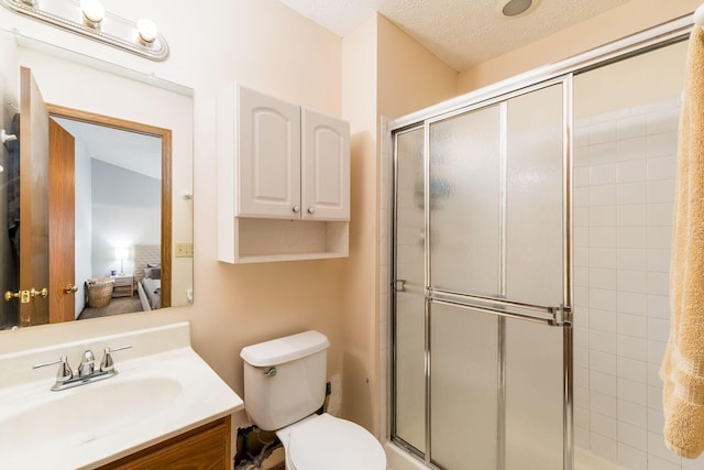 bathroom with toilet, vanity, and tiled shower