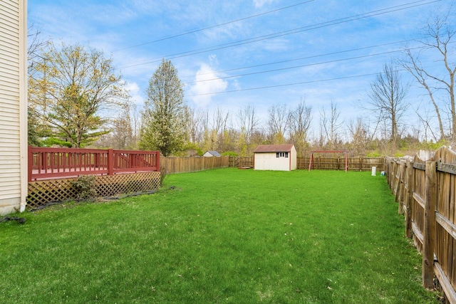 view of yard featuring a fenced backyard, an outbuilding, a shed, and a deck