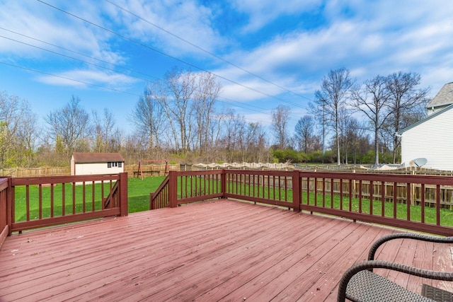 wooden terrace featuring a yard, an outbuilding, a fenced backyard, and a storage unit