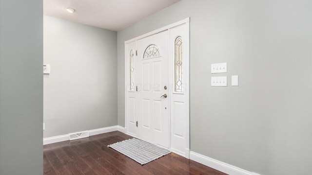foyer entrance featuring baseboards, visible vents, and dark wood-style flooring
