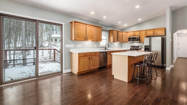 kitchen with lofted ceiling, light countertops, visible vents, a kitchen island, and appliances with stainless steel finishes