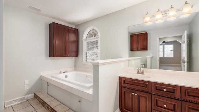 bathroom featuring a bath, baseboards, visible vents, tile patterned flooring, and vanity