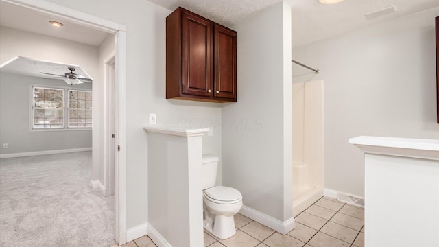 full bath featuring a shower stall, toilet, a ceiling fan, and baseboards