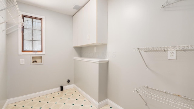 washroom with cabinet space, hookup for a washing machine, baseboards, and light floors