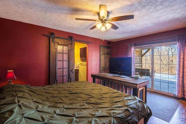 9704 Loudon St, Johnstown, OH 43031 - bedroom with a barn door, wood finished floors, a textured ceiling, access to outside, and ceiling fan