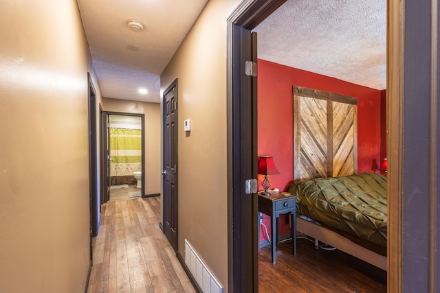 9704 Loudon St, Johnstown, OH 43031 - corridor featuring a textured ceiling, wood finished floors, and visible vents