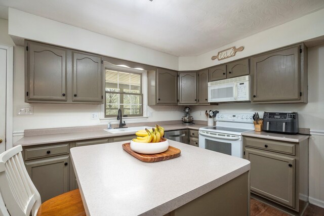 1005 Glenn Ave, Washington Court House, OH 43160 - kitchen with white appliances, a sink, light countertops, a kitchen island, and dark wood finished floors
