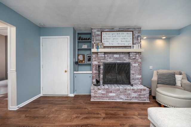 1005 Glenn Ave, Washington Court House, OH 43160 - living area with dark wood-style flooring, a brick fireplace, a textured ceiling, and baseboards