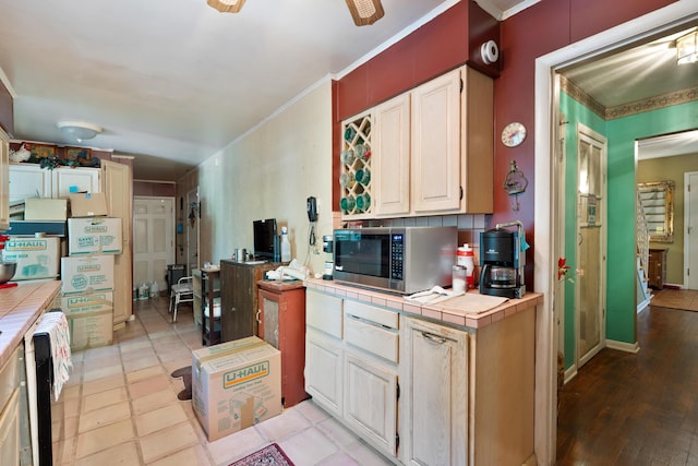 1479 Devonhurst Dr, Columbus, OH 43232 - kitchen featuring tile countertops, stainless steel microwave, ceiling fan, and ornamental molding