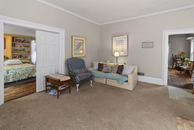 living area featuring baseboards, visible vents, carpet floors, and ornamental molding
