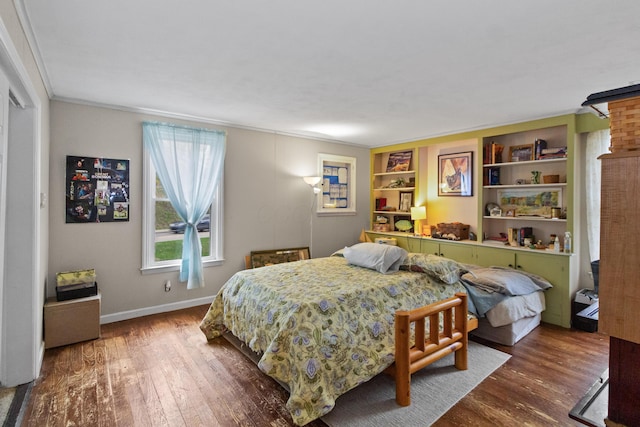 bedroom featuring wood finished floors, baseboards, and ornamental molding