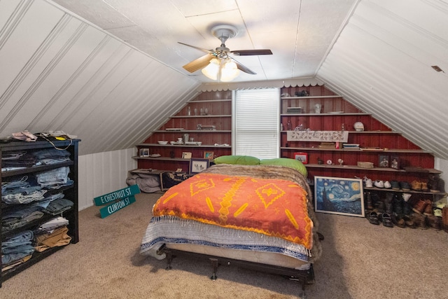 carpeted bedroom with wooden walls, lofted ceiling, and a ceiling fan