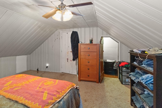 bedroom with ceiling fan, lofted ceiling, wood walls, and carpet floors