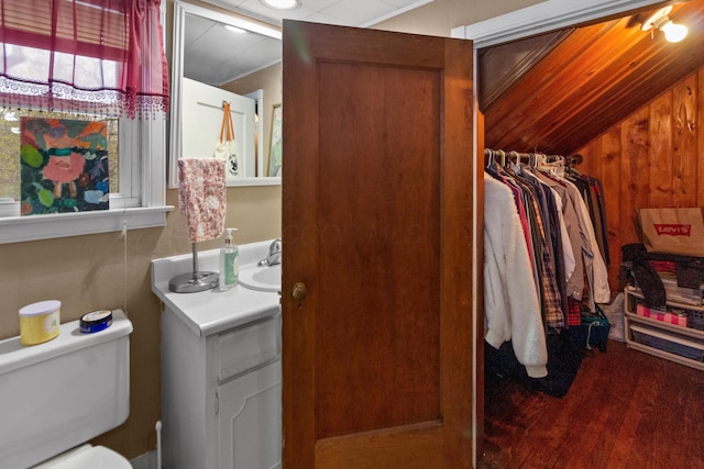 bathroom featuring vaulted ceiling, wood finished floors, toilet, and vanity