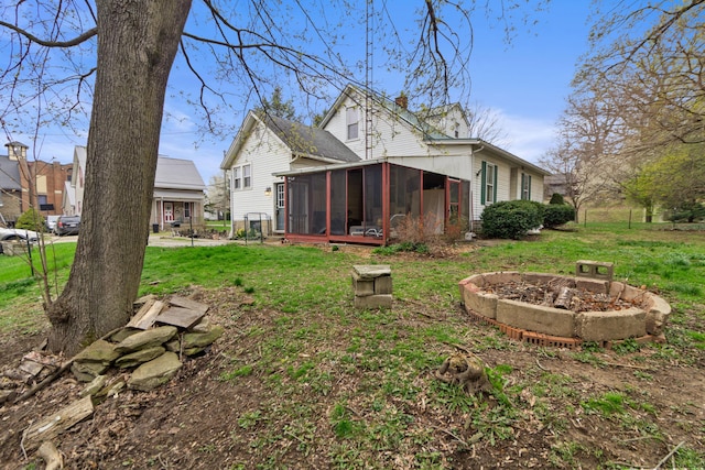 rear view of house with a lawn and a sunroom