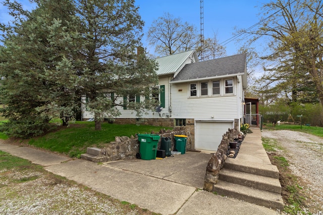 view of front of house with a garage, metal roof, and concrete driveway