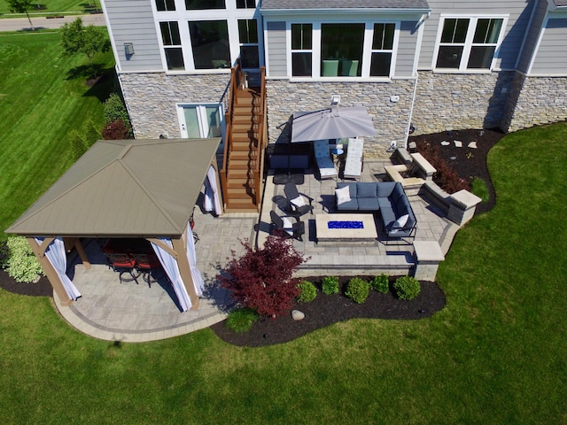 rear view of property with stone siding, a patio area, outdoor lounge area, and a yard