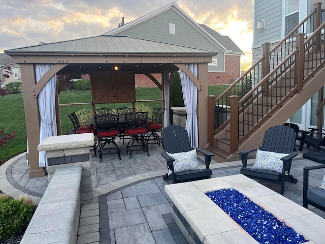 view of patio with a gazebo, outdoor dining area, stairway, and an outdoor living space