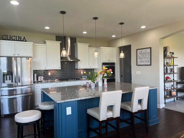 kitchen with white cabinets, stainless steel appliances, dark wood-style floors, and wall chimney range hood