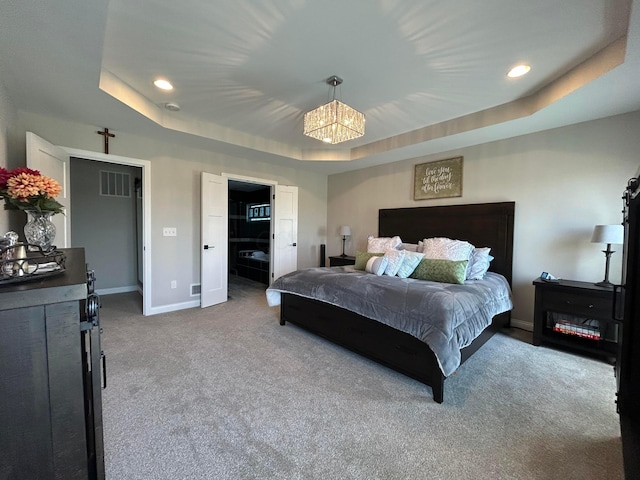 bedroom featuring carpet flooring, visible vents, baseboards, a notable chandelier, and a raised ceiling