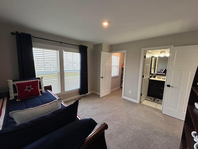 bedroom with light colored carpet, baseboards, ensuite bathroom, and recessed lighting