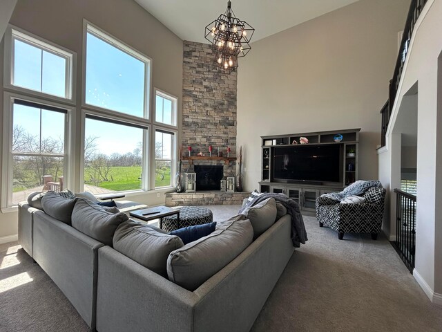 living room featuring a fireplace, a chandelier, carpet flooring, and a towering ceiling