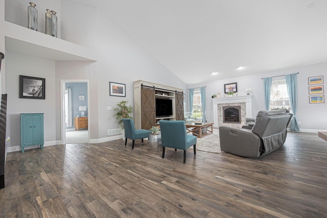 living area featuring a fireplace, dark wood finished floors, plenty of natural light, and high vaulted ceiling