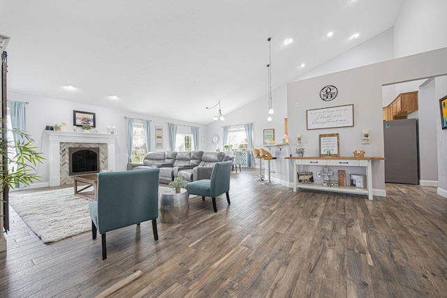living area with dark wood-type flooring, a high end fireplace, high vaulted ceiling, and recessed lighting