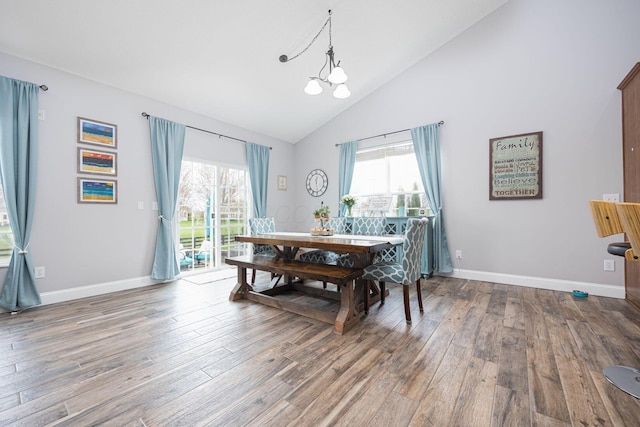 dining area featuring baseboards, wood finished floors, a wealth of natural light, and high vaulted ceiling