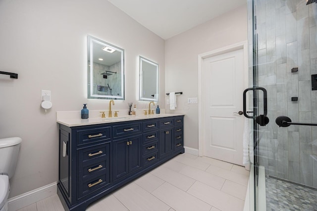full bathroom featuring double vanity, toilet, a stall shower, and a sink