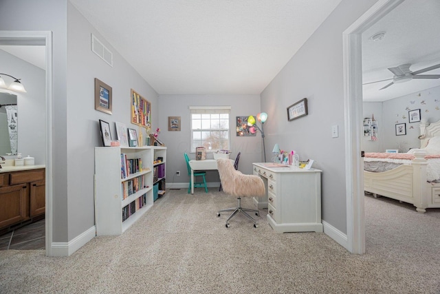 carpeted office featuring visible vents, a ceiling fan, and baseboards