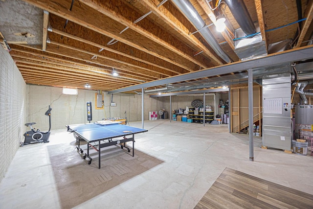 unfinished basement with electric panel, heating unit, and gas water heater