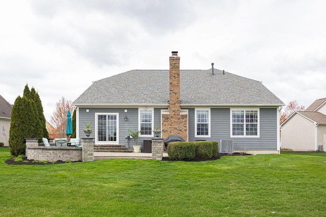 back of property with central AC unit, a yard, and a shingled roof