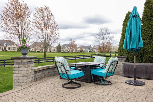 view of patio featuring a residential view, outdoor dining area, and fence