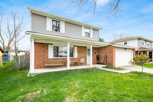 traditional home with a front lawn, driveway, covered porch, and a garage