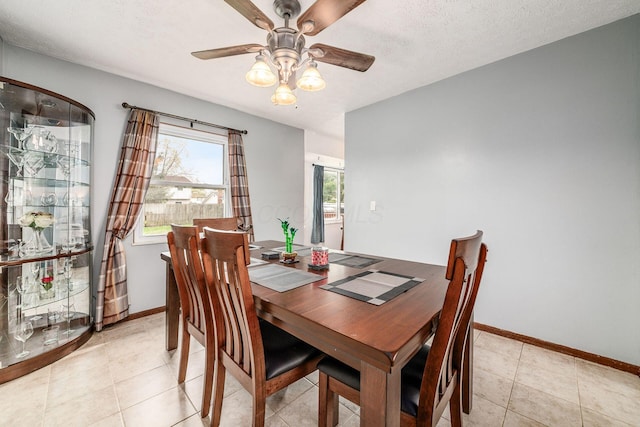 dining room featuring baseboards, a ceiling fan, and light tile patterned flooring