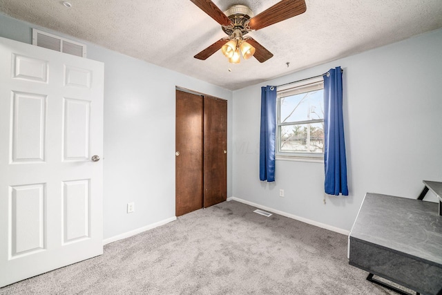 unfurnished bedroom featuring visible vents, carpet floors, and a textured ceiling