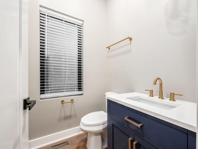 496 W 1st Ave, Columbus, OH 43201 - half bathroom featuring toilet, vanity, and wood finished floors