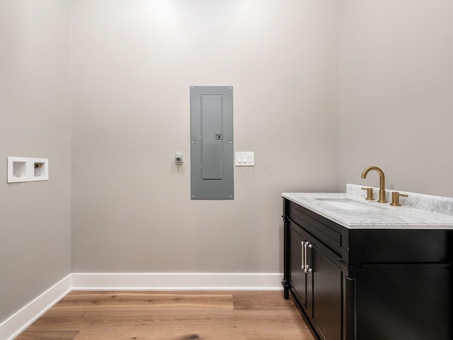 496 W 1st Ave, Columbus, OH 43201 - washroom with electric panel, light wood finished floors, baseboards, and hookup for a washing machine