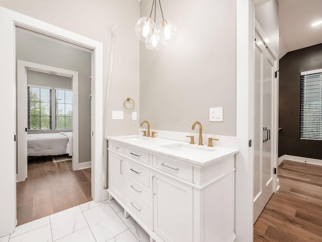 496 W 1st Ave, Columbus, OH 43201 - ensuite bathroom with a chandelier, baseboards, double vanity, and wood finished floors