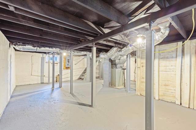 unfinished basement with electric panel, heating unit, and stairs