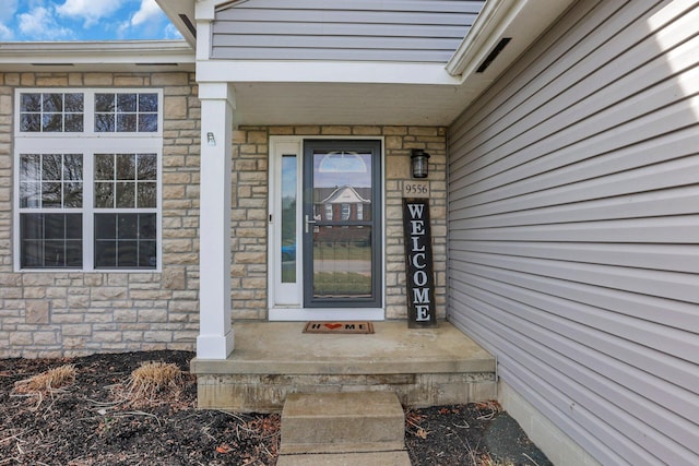 view of exterior entry featuring stone siding