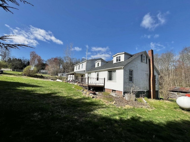 view of property exterior featuring a yard, a chimney, and a deck