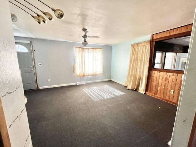 unfurnished living room with ceiling fan, baseboards, and a wealth of natural light