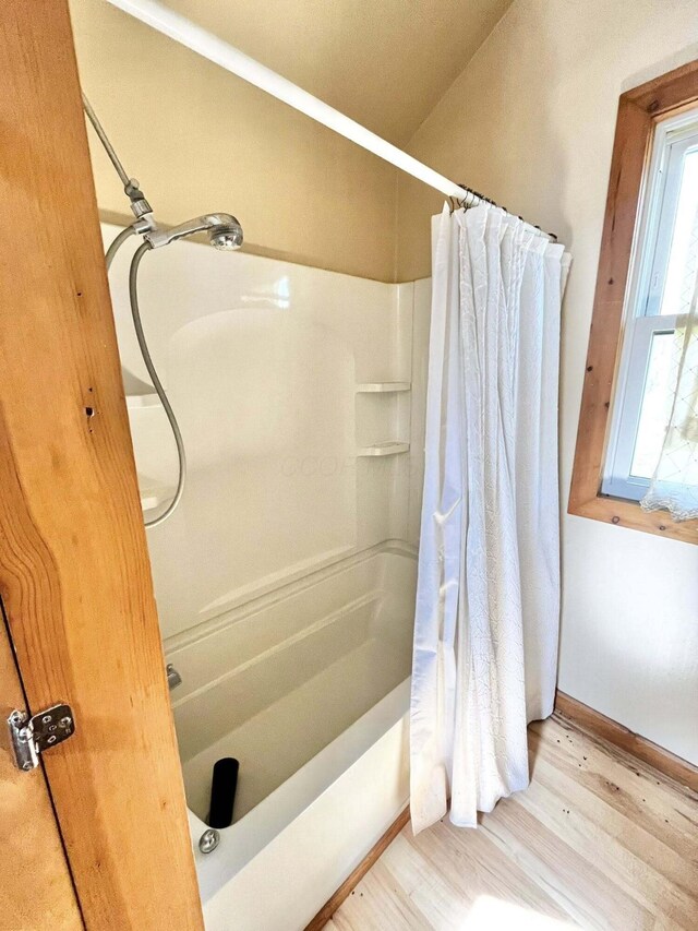 bathroom with baseboards, a shower with curtain, and wood finished floors