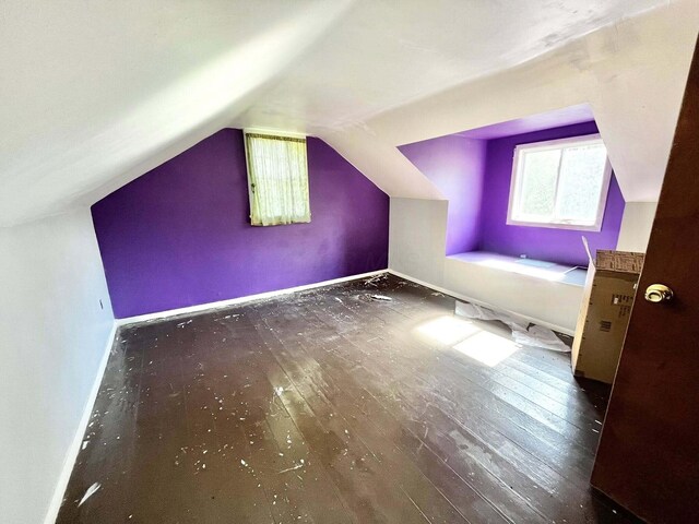 bonus room featuring wood-type flooring, lofted ceiling, and baseboards