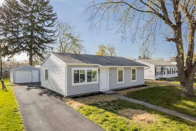 bungalow with an outdoor structure, a shingled roof, a front lawn, and a garage